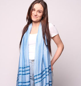 Woman wearing blue scarf with dark blue stripe